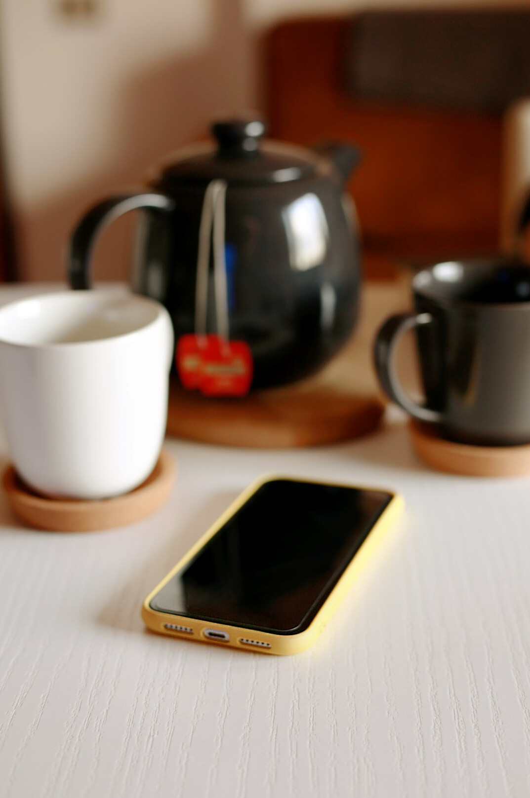 Smartphone showing a chat conversation next to a cup of tea