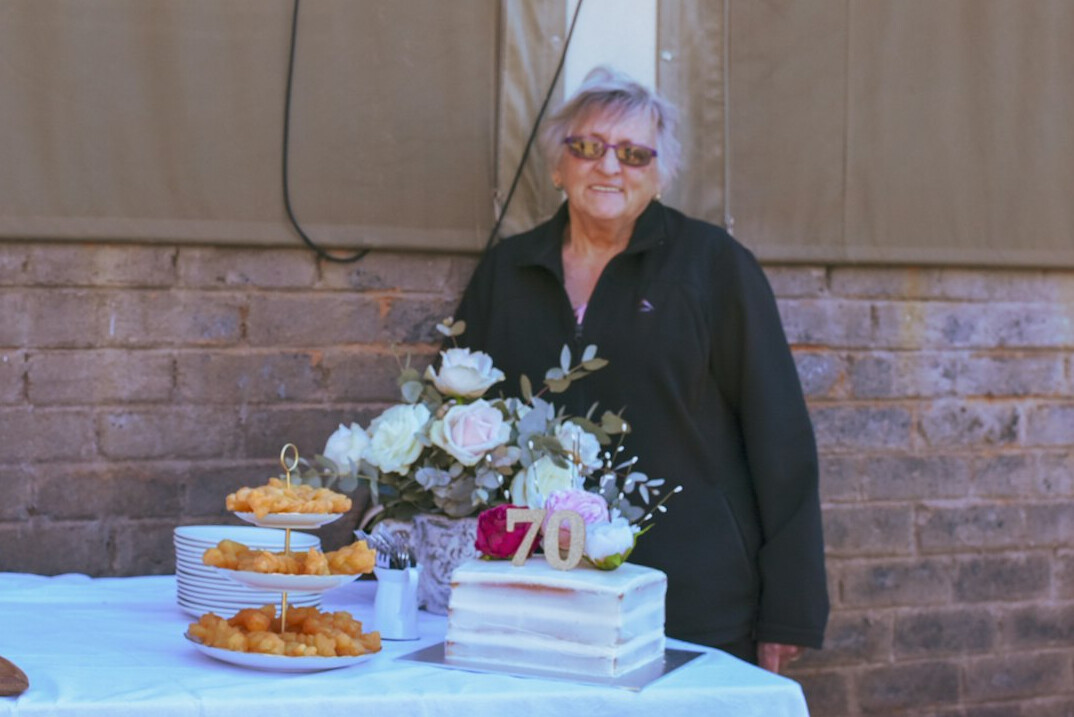 Smiling senior woman reading documents at a bright kitchen table